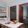 Cucina con tavolo, fruttiera e ingresso ad altre camere.