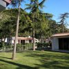 Giardino con prato, alberi e villette bianche.