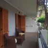 Balcone con poltrone, vista su giardino e alberi.