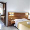 Stanza con letto matrimoniale e porta aperta verso un'altra stanza.
