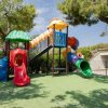 Parco giochi colorato con scivoli tubolari e strutture di arrampicata.