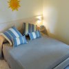 Camera da letto con cuscini a righe blu e decorazione a forma di sole.