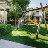 Parco giochi con altalene e scivolo giallo.