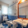 Bagno con piastrelle blu e bianche, lavabo, bidet e doccia.