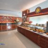 Lobby luminosa con un bancone bar e un tavolo con frutta fresca e stoviglie.