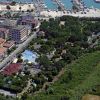 Vista aerea di un'area residenziale con piscina, vicino a un porto turistico.