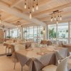 Ristorante elegante con tavoli apparecchiati e soffitto in legno.