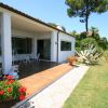 Veranda di una casa con giardino e arredi bianchi.