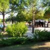 Un giardino alberato con una piscina e alcune persone vicino a un edificio.