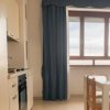 Interno di una cucina con tavolo bianco e tende blu.