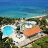 Veduta aerea di un resort con piscina e vista mare.