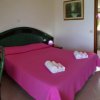 Letto matrimoniale rosa con asciugamani piegati.