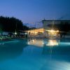 Una piscina illuminata di notte con luci riflesse sull'acqua.