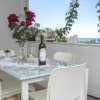 Tavolo con bicchieri di vino e rose rosse, affacciato su una vista mare.