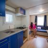 Cucina blu con due persone sedute su un divano in un piccolo soggiorno.