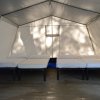 Interno di una tenda con quattro letti singoli allineati.