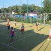 Partita di pallavolo su un campo all'aperto con persone impegnate a giocare.