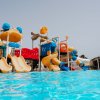 Parco acquatico con scivoli gialli e arancioni, giochi d'acqua blu e rossi, immerso in una piscina.