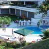 Persone attorno a una piscina all'aperto di un complesso moderno.