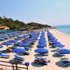 Spiaggia affollata con ombrelloni blu allineati lungo la costa.