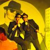 Due uomini in abiti neri e occhiali da sole cantano su un palco con un murale dietro.