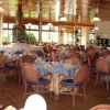 Sala ristorante elegante con tavoli apparecchiati e sedie in vimini.