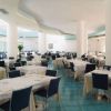 Sala ristorante ampia con tavoli apparecchiati e sedie blu.