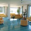 Sala luminosa con divani gialli e ampie finestre.
