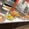 Buffet con piatti di salumi e formaggi affettati, torte salate e pile di piatti bianchi.