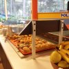 Tavolo da colazione con croissant, banane e pere vicino a grandi finestre.