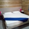 Camera da letto con letto matrimoniale, due comodini e lampade rosa.