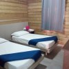 Due letti singoli con coperte blu, pareti in legno.