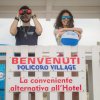 Due persone dietro un'insegna di benvenuto a Policoro Village.