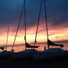 Vele di barche al tramonto con cielo colorato.
