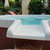 Vasca idromassaggio con acqua che trabocca in un giardino.