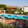 Una piscina circondata da lettini, ombrelloni e persone.