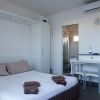 Camera da letto moderna con letto matrimoniale, tavolo, due sedie e bagno annesso.
