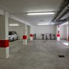 Parcheggio seminterrato con una macchina e varie biciclette.