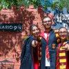 Tre persone in costumi da maghi davanti a un set di Harry Potter.
