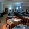 Ristorante con tavoli apparecchiati in tono neutro.