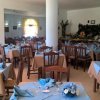 Sala da pranzo con tovaglie blu e quadri alle pareti.
