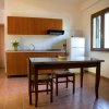 Cucina piccola con tavolo, sedie e finestra.