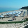 Spiaggia con file di ombrelloni e sdraio.