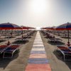 Ombrelloni e lettini vuoti su una spiaggia al tramonto.