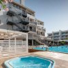 Idromassaggio e piscina esterna di un hotel moderno con scale antincendio.