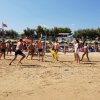 Persone giocano a volleyball sulla sabbia.