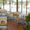 Interno di un ristorante con tavoli apparecchiati e cartello che dice 