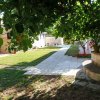 Giardino con un sentiero lastricato circondato da alberi e piante.