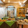 Buffet di dolci e cereali su tavoli verdi in una sala interna con muri in pietra.