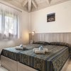 Camera da letto con letto matrimoniale, copriletto decorato e soffitto con travi a vista.